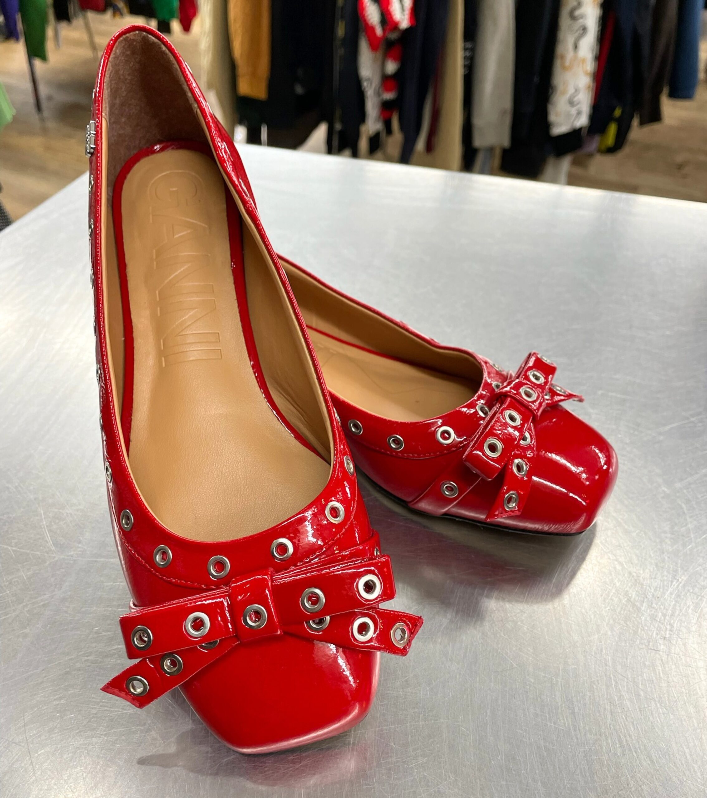 Red patent leather Ganni flats with grommets and bow