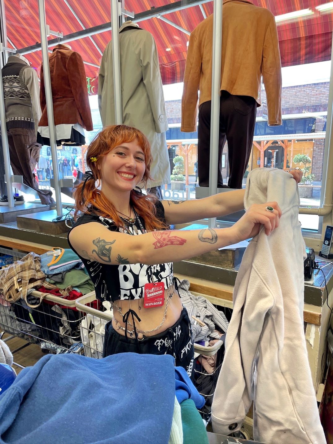 Buffalo Exchange employee holding up a piece of clothing